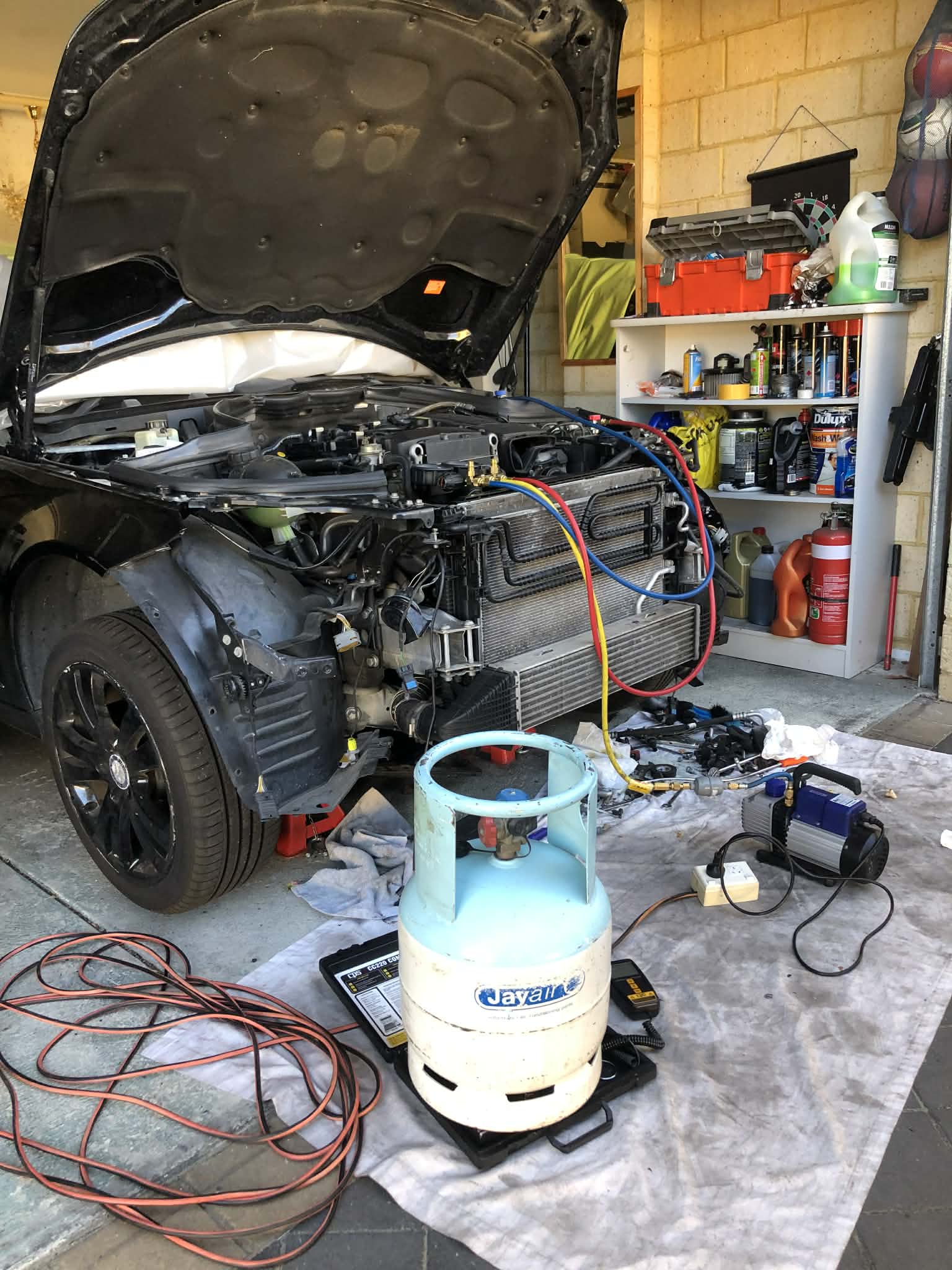 Black vehicle with its front bumper removed for air conditioning repairs