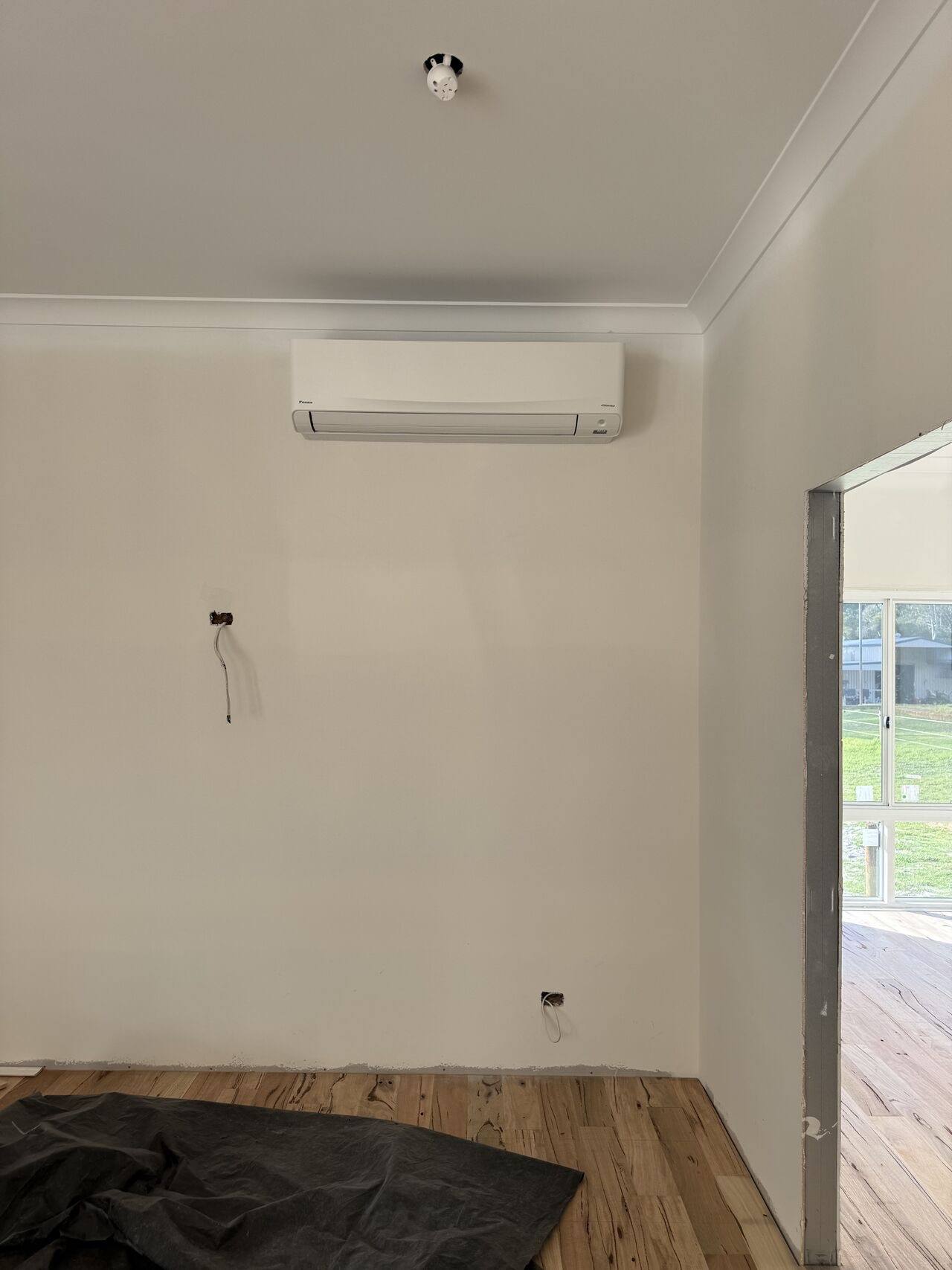New split system head mounted high on a wall in an empty living room