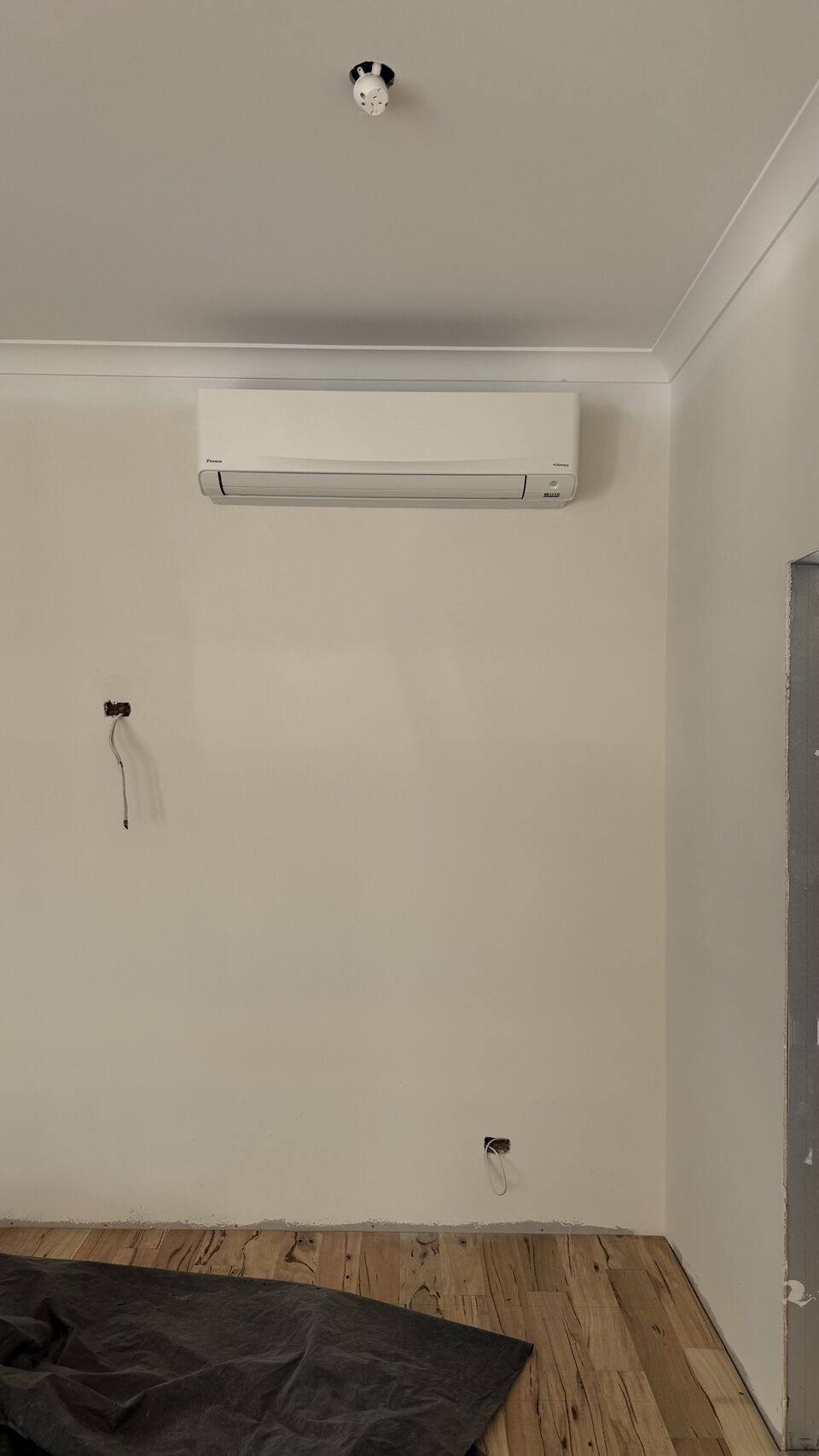 New split system head mounted high on a wall in an empty living room